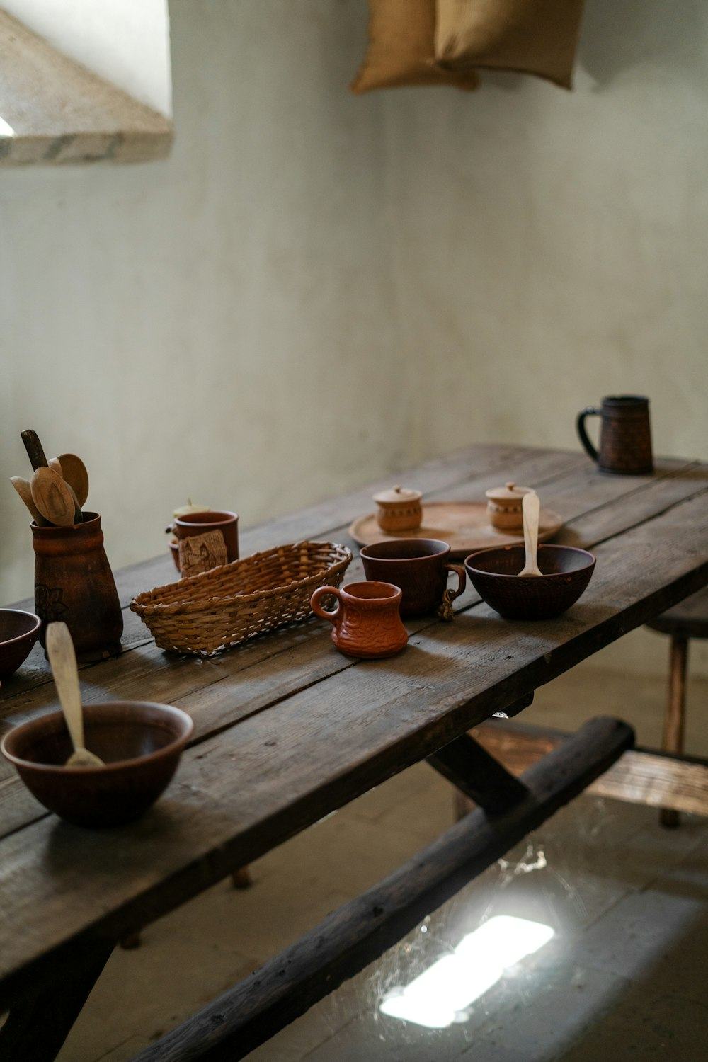 Handmade ceramics and wooden spoons on a rustic table