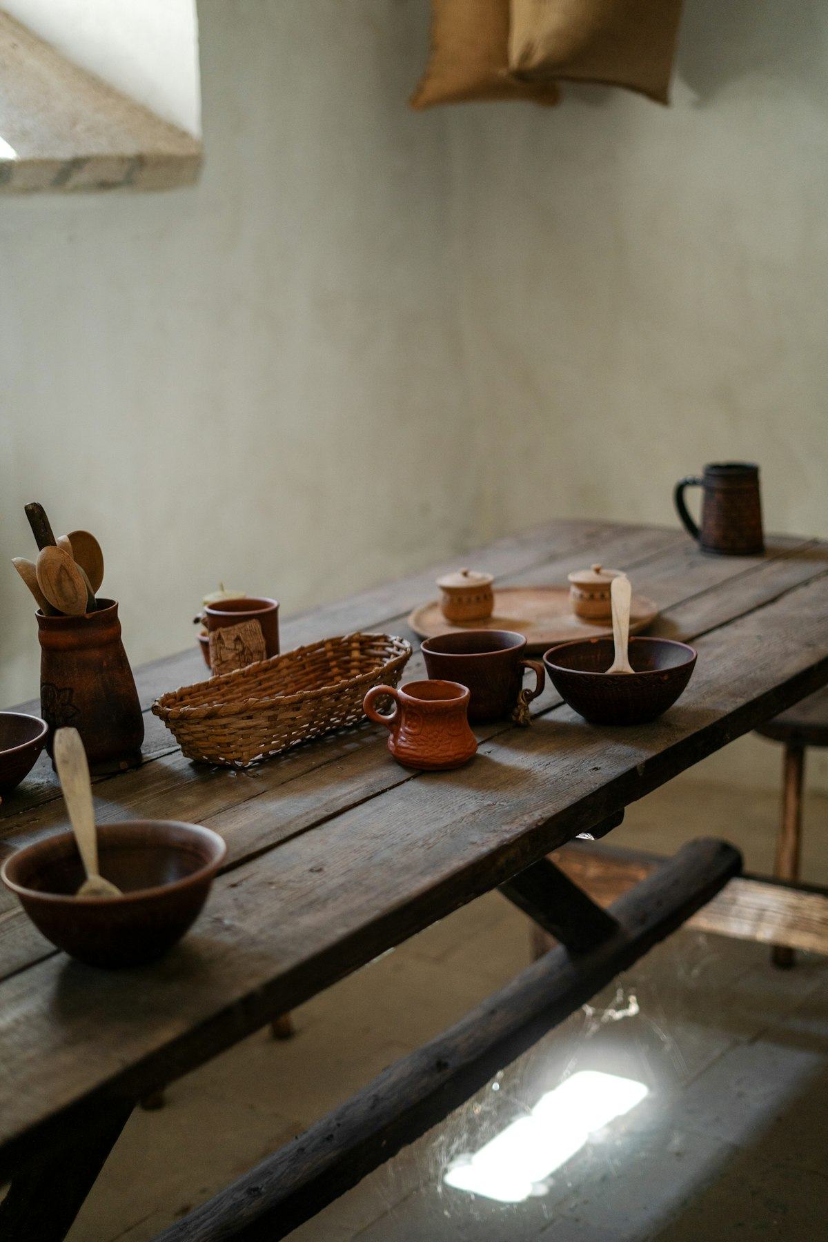 Handmade ceramics and wooden spoons on a rustic table