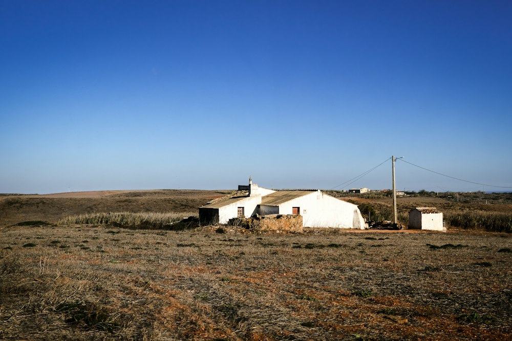 A low white farmhouse in a dry inland landscape